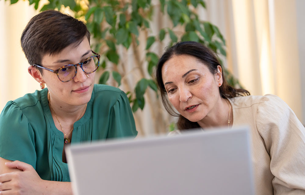 Two people sitting at a laptop