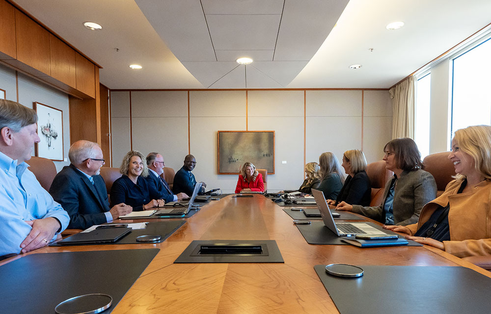 Management committee sits at a long table discussing issues
