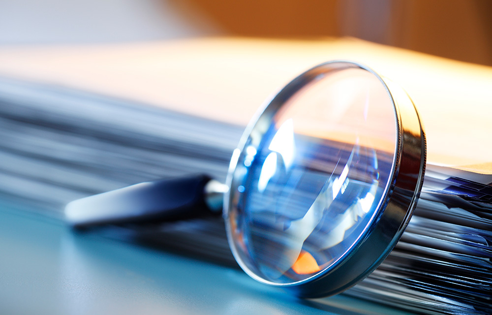 Magnifying glass atop a blurry blue and yellow background