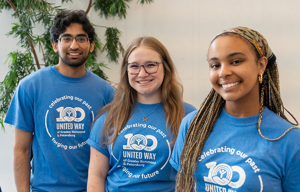 Three early career professionals standing together