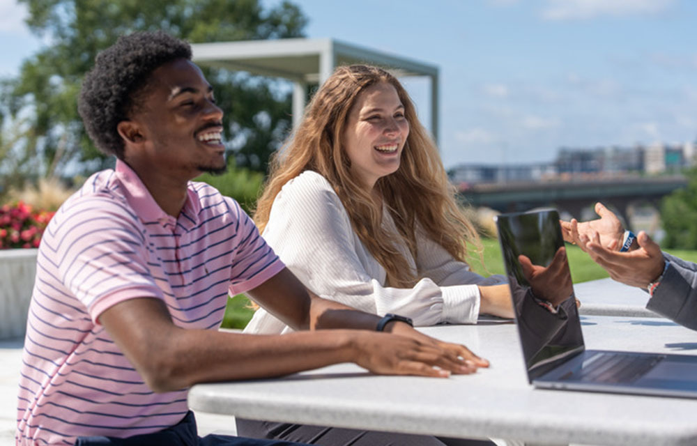 Two people sitting at a table outside