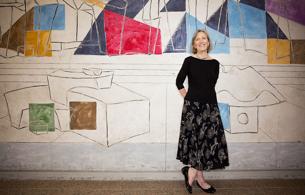 Photo of Claudia Goldin in front of an artistic background