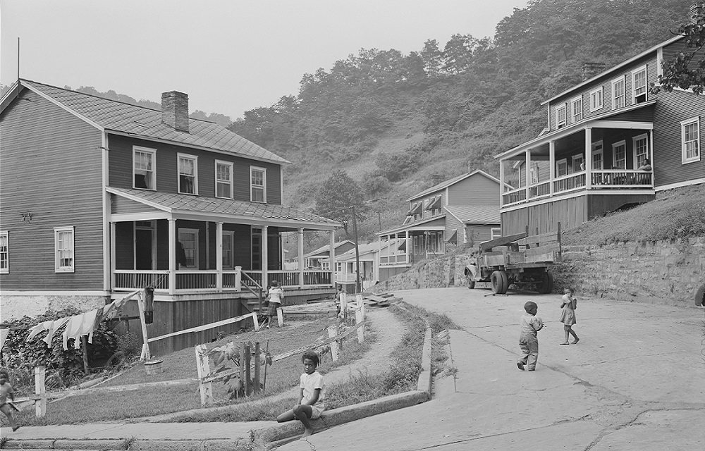 Black and white scene of a company town neighborhood with kids playing.