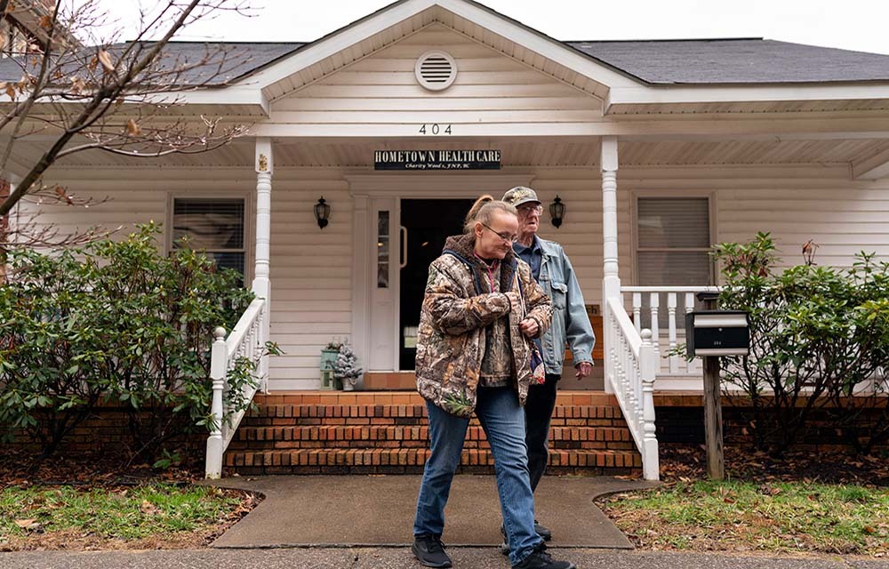 An older couple walks out of a medical practice called "Hometown Healthcare" in rural West Virginia.