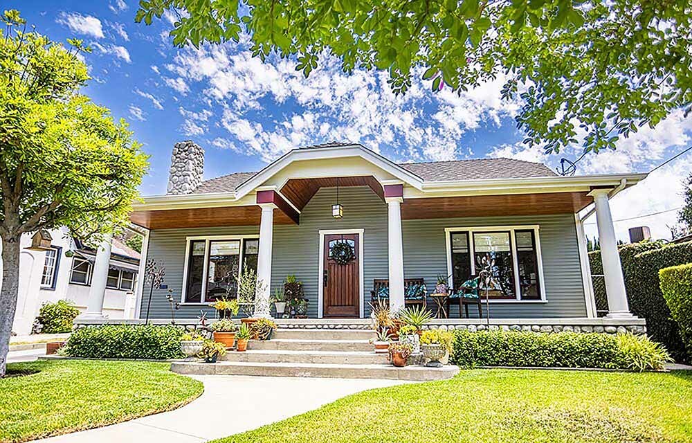 The front of a nice 1-story house with a yard and sidewalk in a suburban neighborhood.