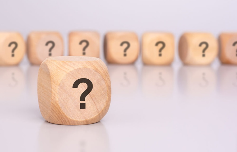 Wooden dice with question marks on one side.