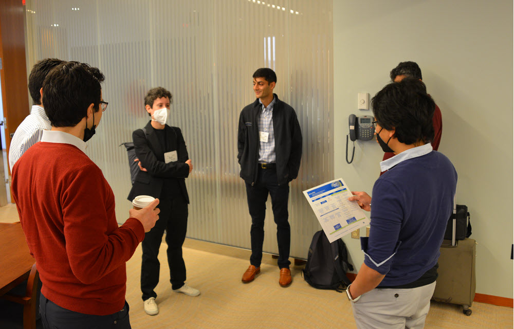  Economists actively engaged in discussion during a break between seminars in the May CORE Week.