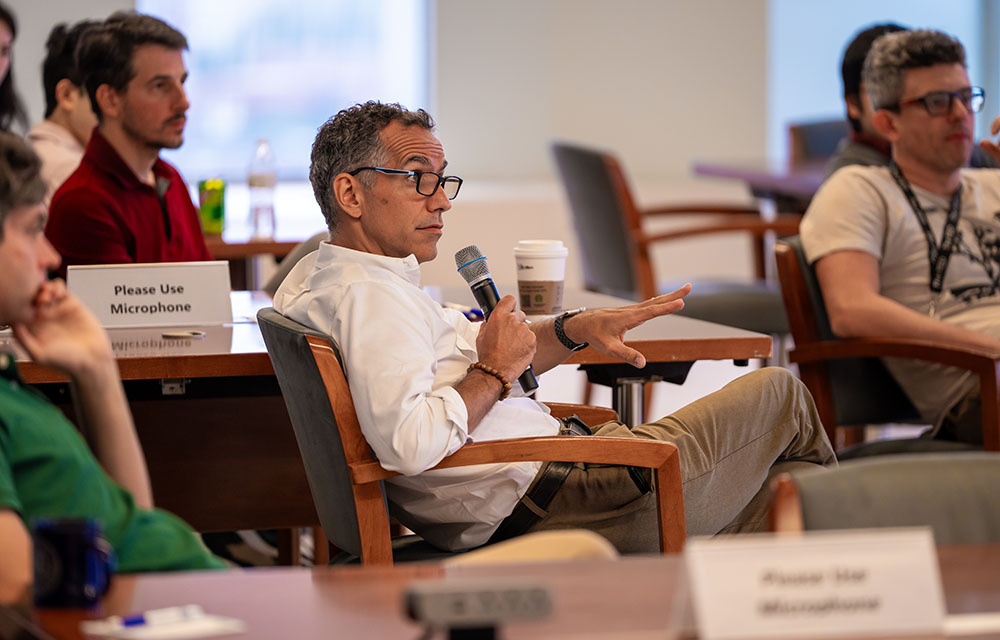 Audience member holding a microphone and asking questions at CORE Week.