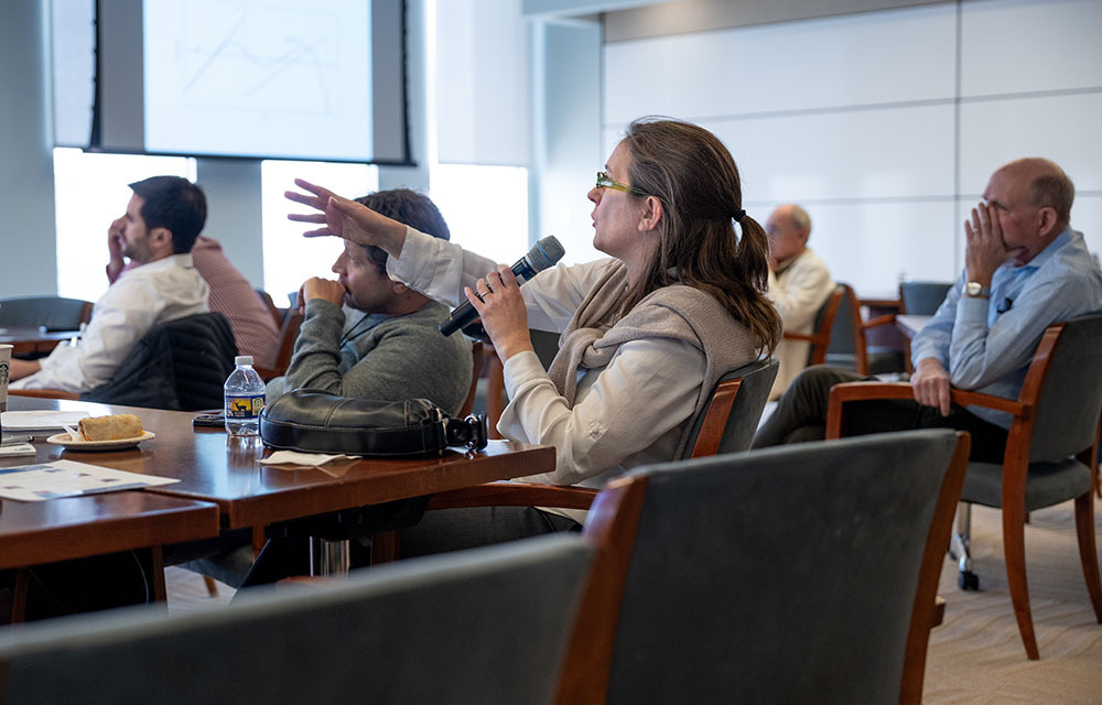 Marina Azzimonti using a microphone to ask a question from the audience.