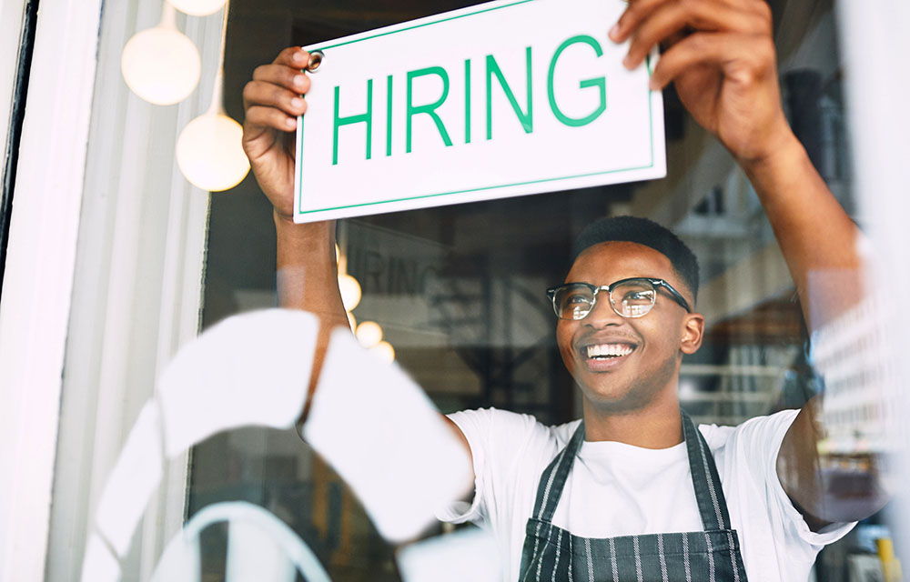 man_hiring_sign_window