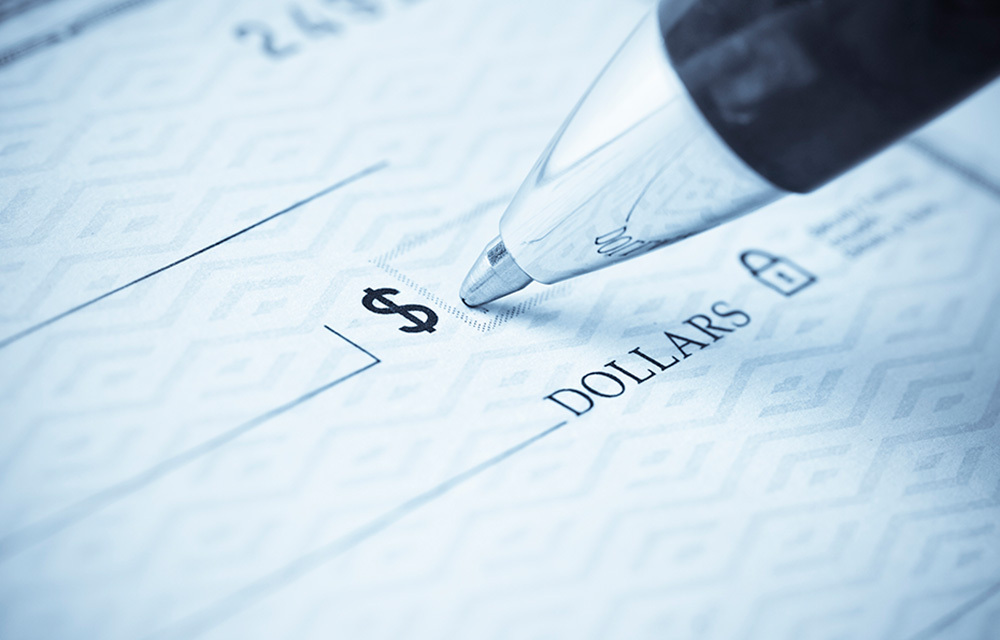 close up of a pen writing on a check