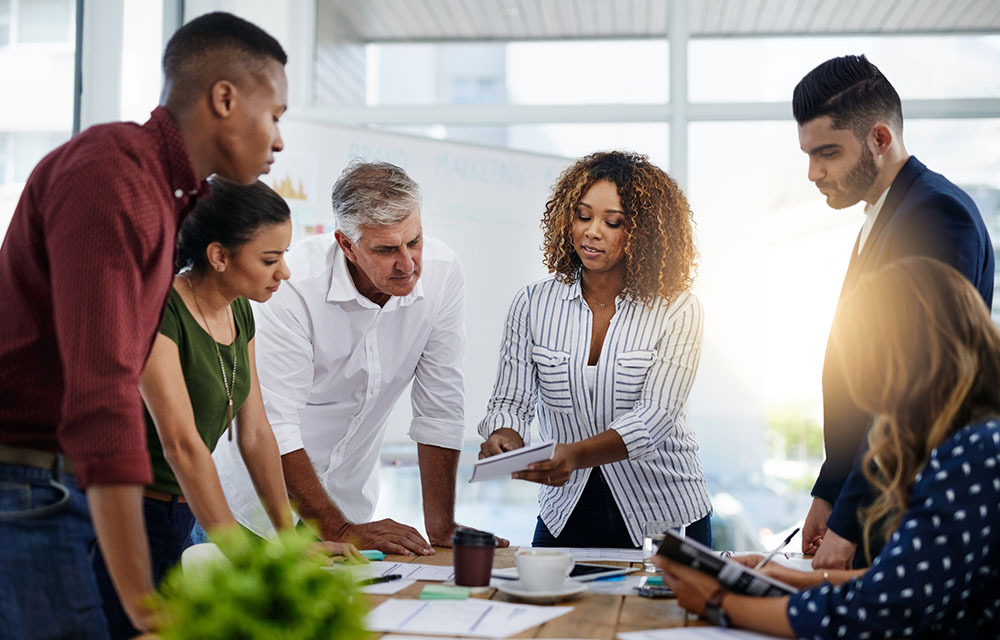 Group of employees discuss ideas around a table