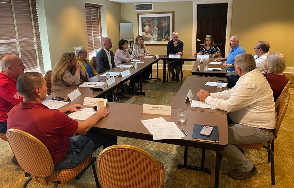 Regional executives meeting with business leaders around a conference table.