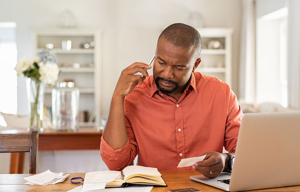 a man reviews his paperwork at a computer