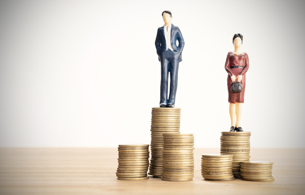 Figures of man and woman standing on stacks of coins, with the man higher than the woman