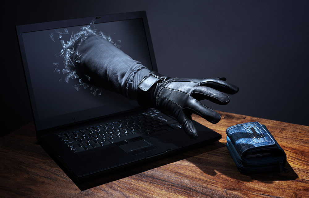 Hand reaching out of laptop screen to steal wallet