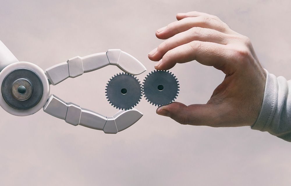 Robot hand giving a gear to a human hand.