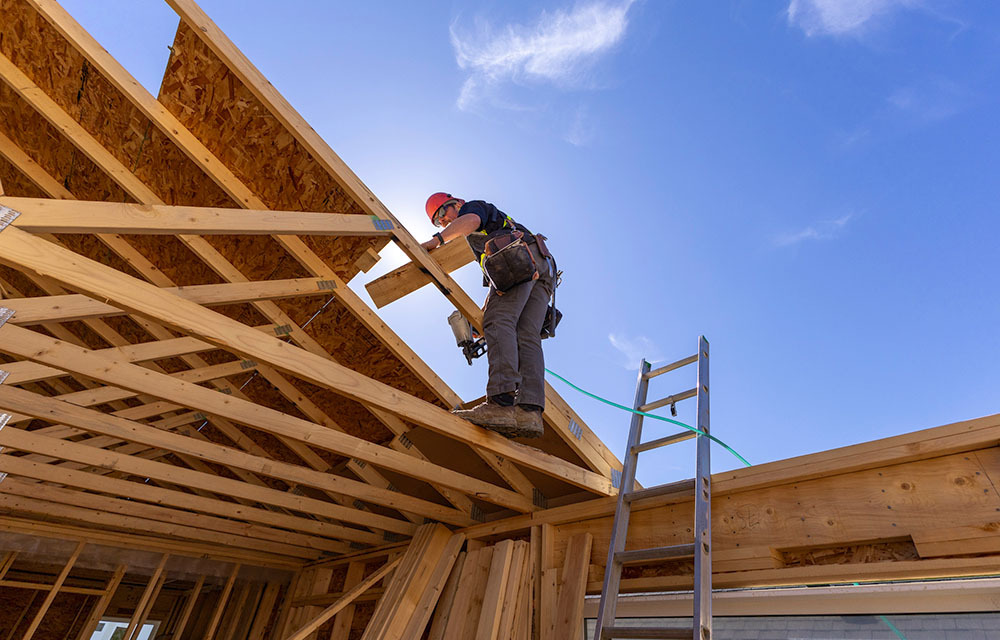 construction worker framing a roof