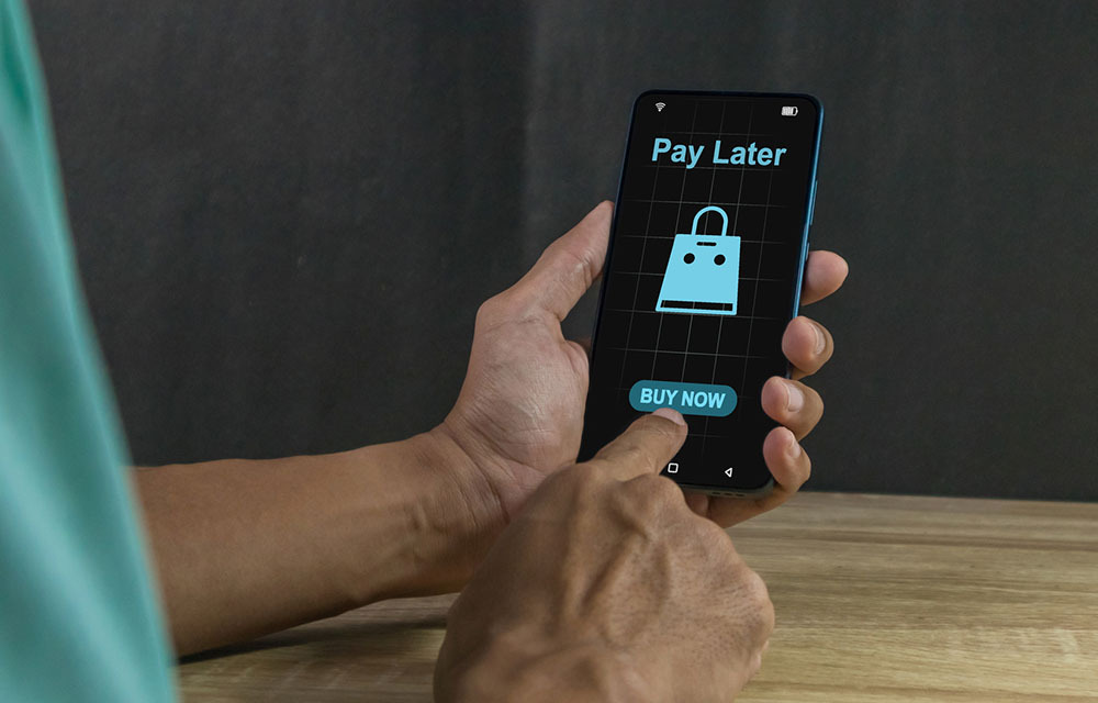 Man holding his smartphone with a buy now, pay later payment option dispkayed on the screen