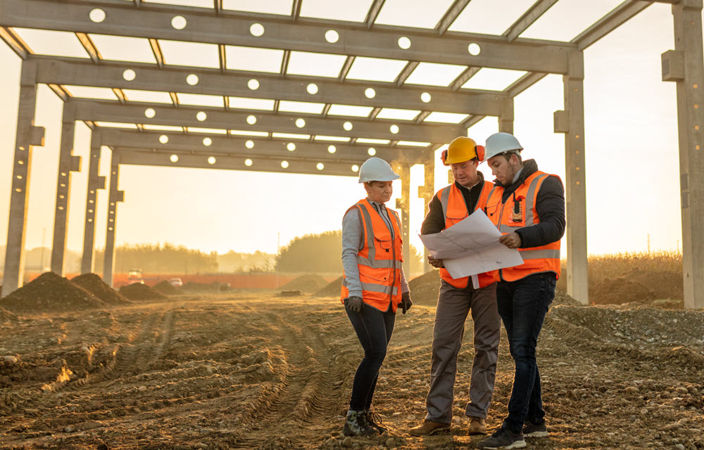 Constuction workers looking at plans for major development on a rural site