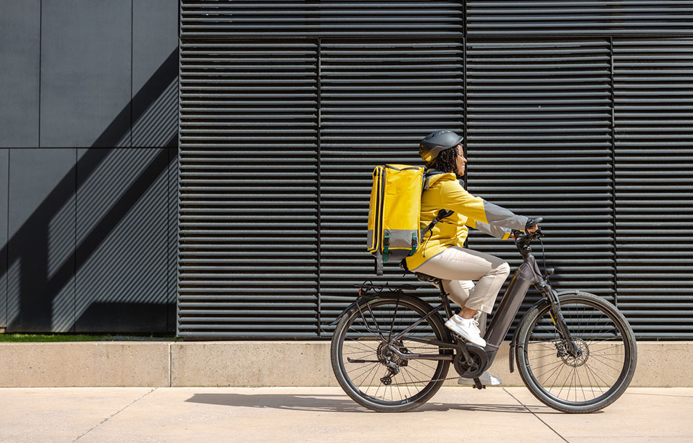 Delivery woman riding on e-bike