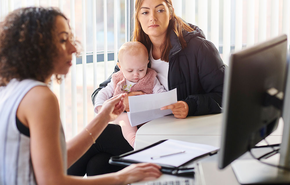 woman advising another woman who is holding a baby