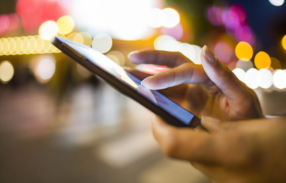 woman's fingers run across a phone