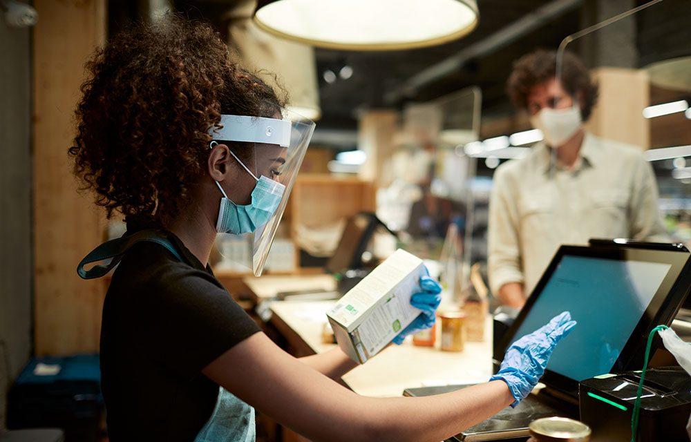 descriptive image of a cashier demonstrating employment recovery from the pandemic