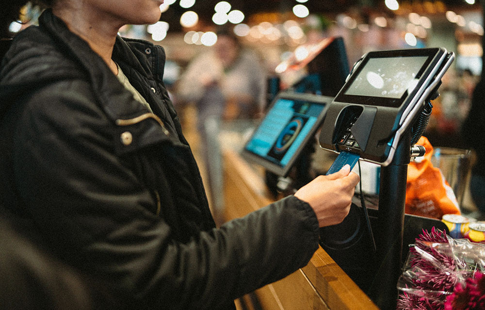 Woman using her card's chip to pay for items at the grocery store.