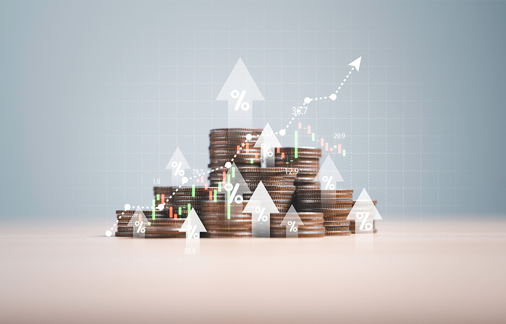 An overlay of upward-facing arrows with percent signs and stock market charts over top of assorted stacks of coins.