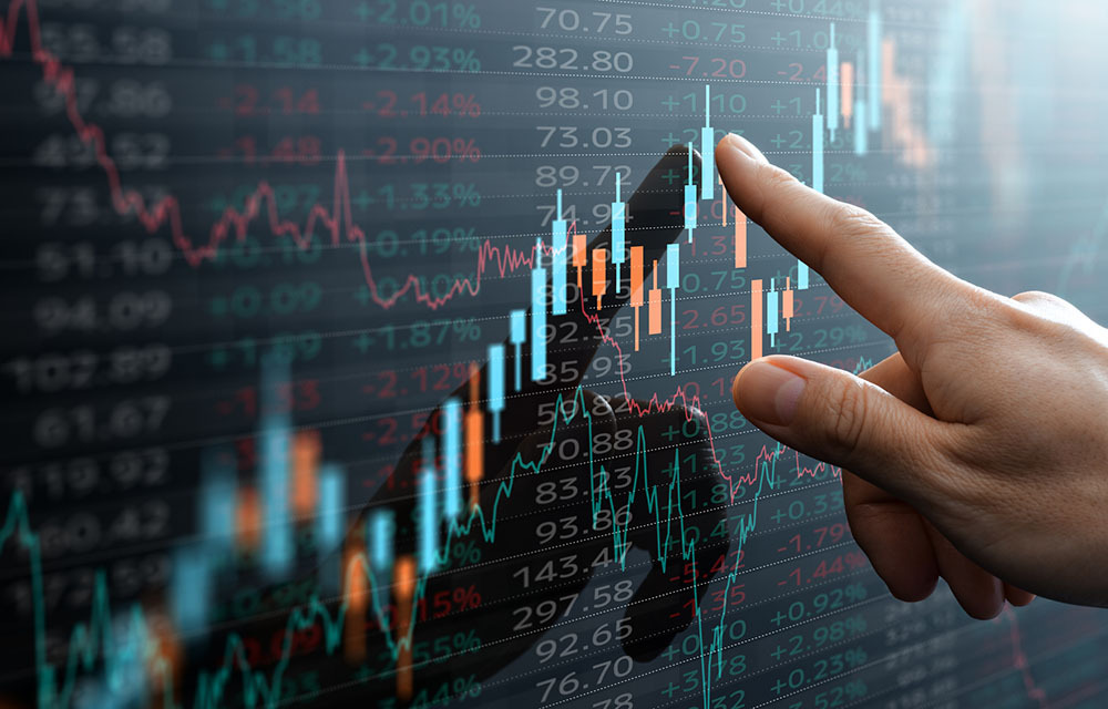 Financial analyst pointing to data on a stock market chart.