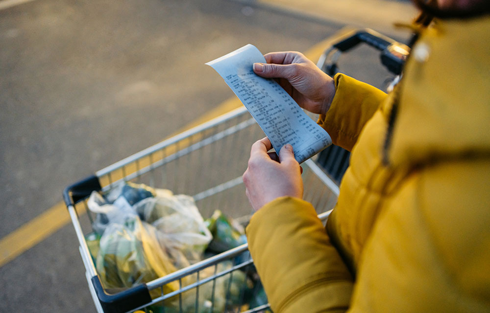 Woman looking through purchases on her grocery receipt.
