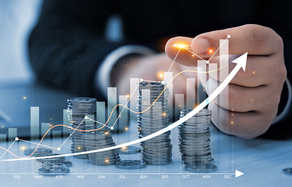 Businessman stacking coins with an overlay of an upward trending chart.