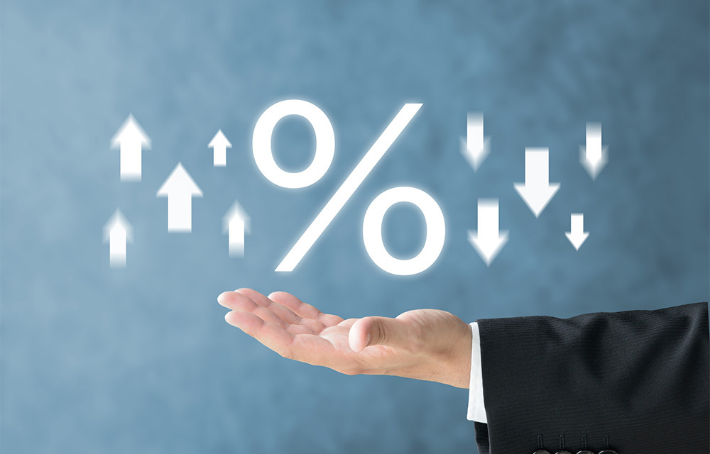 Businessman's palm holding a percentage sign with upward and downward arrows.