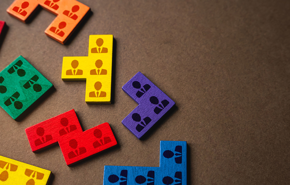 Wooden blocks with a worker icon with organized into colorful sections.