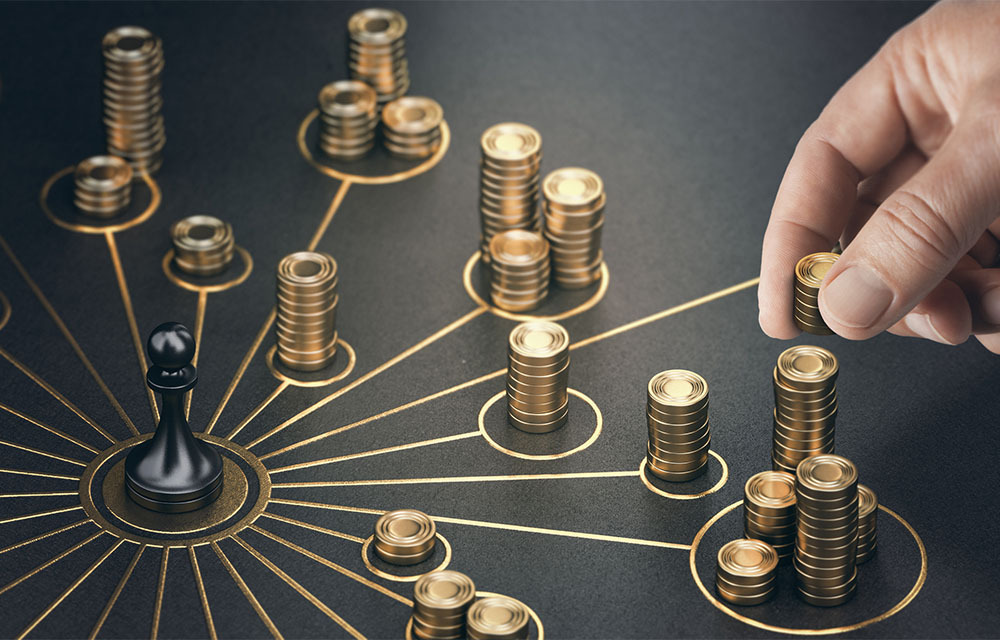 Hand sorting coins into various stacks to represent funding being distributed.