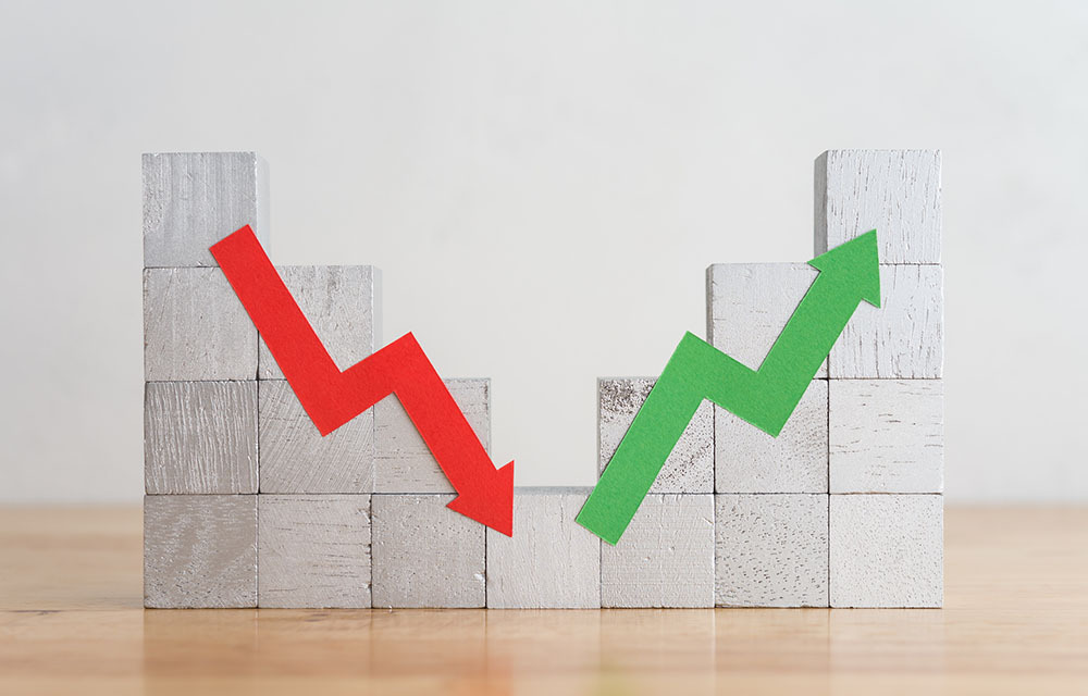 Stacked wooden blocks with a red arrow trending downwards on the left and a green arrow trending upwards on the right.