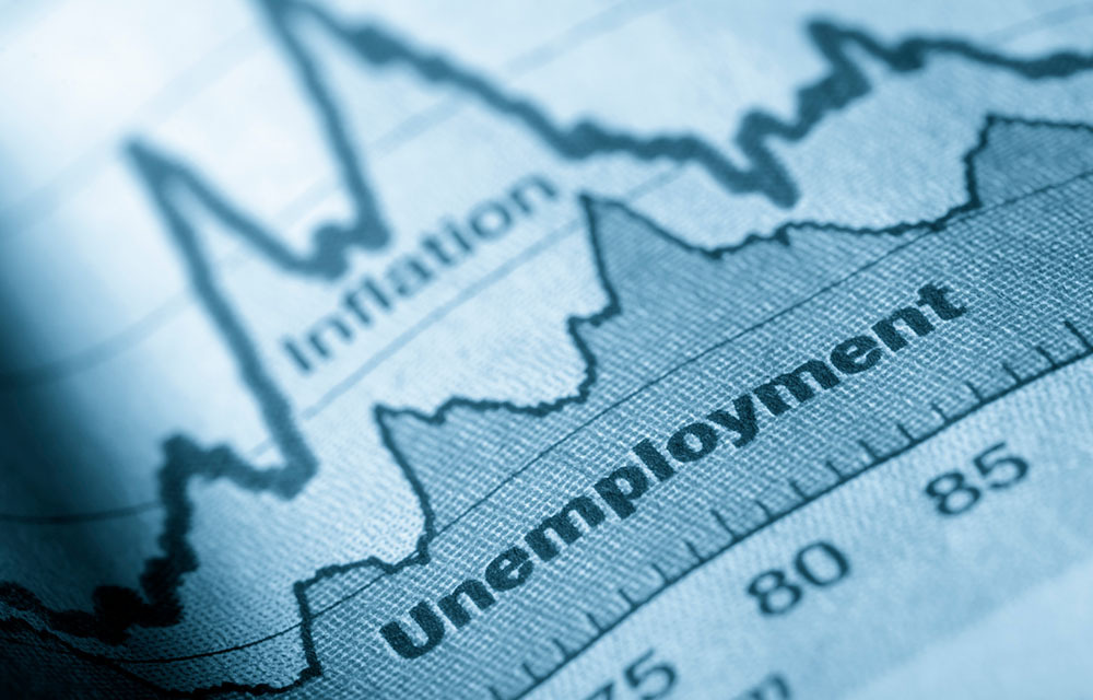 Close up of graph on paper showing an unemployment trend line with a faint inflation trend line above.