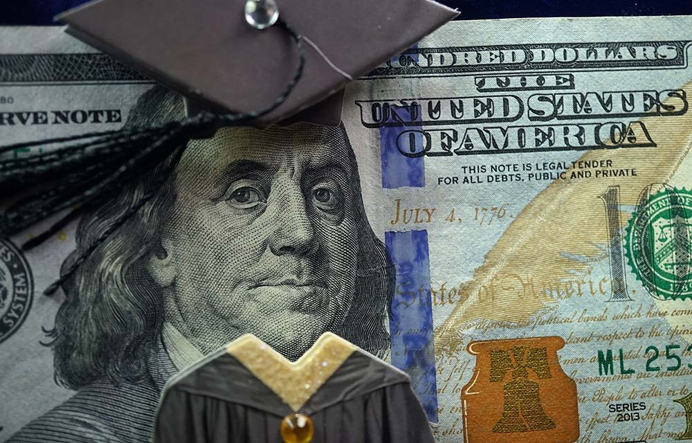 Close up of hundred-dollar bill with Benjamin Franklin wearing a graduation cap and gown.