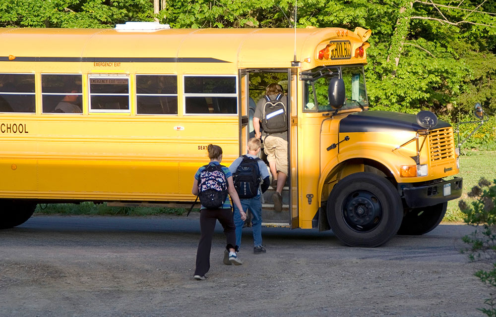 Kids getting on a school bus