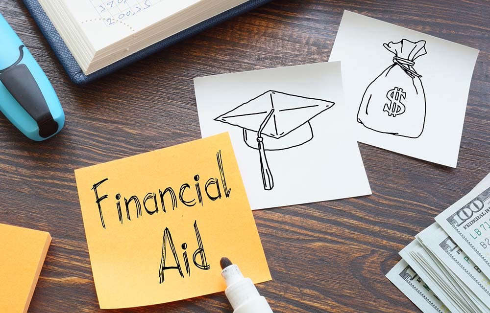 Sticky notes with the words financial aid, a graduation cap, and a money bag written in marker.