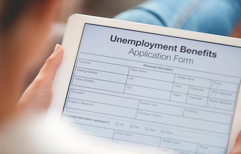Woman filling out form for unemployment benefits.