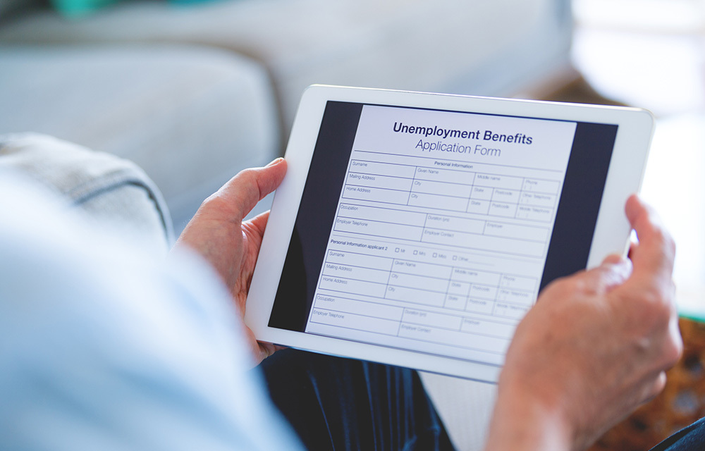 Person filling out an unemployment form on their tablet.
