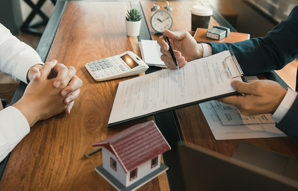 Lender going over mortgage agreement with a homebuyer.