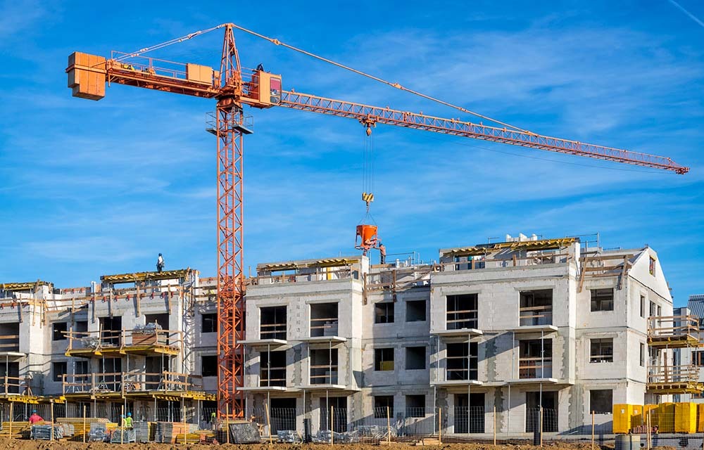 A crane and construction equipment being used to build a new apartment complex