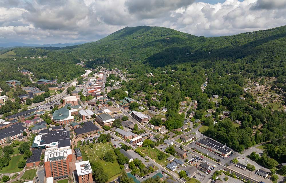 Overlook view of Boone, North Carolina, a small town nestled between green mountains.
