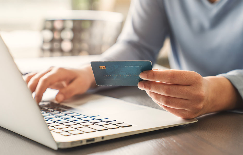 A man typing his credit card information in while online shopping.