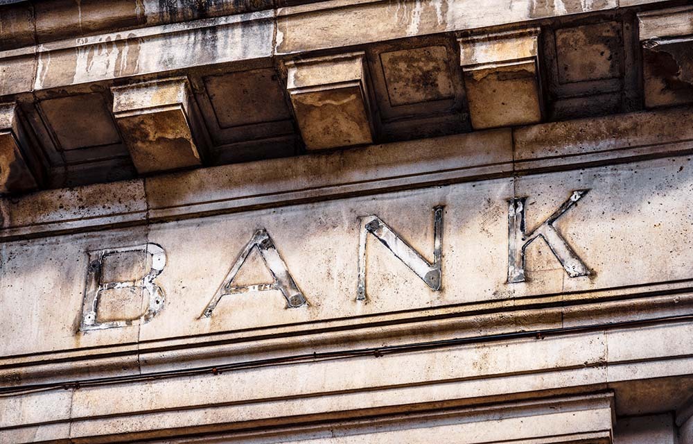 Old building with aged letters spelling out "bank."