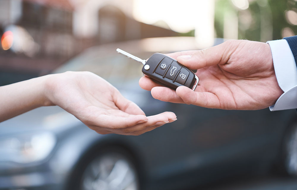 Car dealer handing keys over to a buyer.