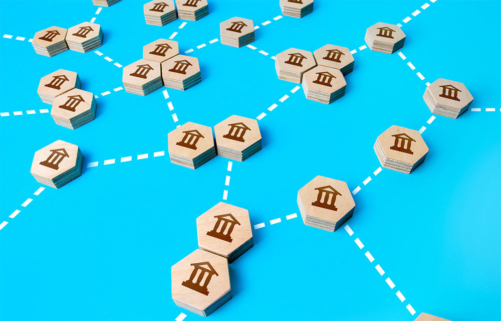 Wooden blocks with bank icons connected with dotted lines.